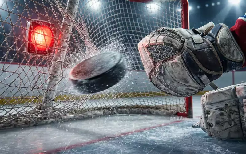 Eishockeytor mit Puck im Netz symbolisiert Over Under Torwetten